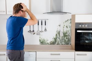 man-upset-about-mould-in-his-kitchen